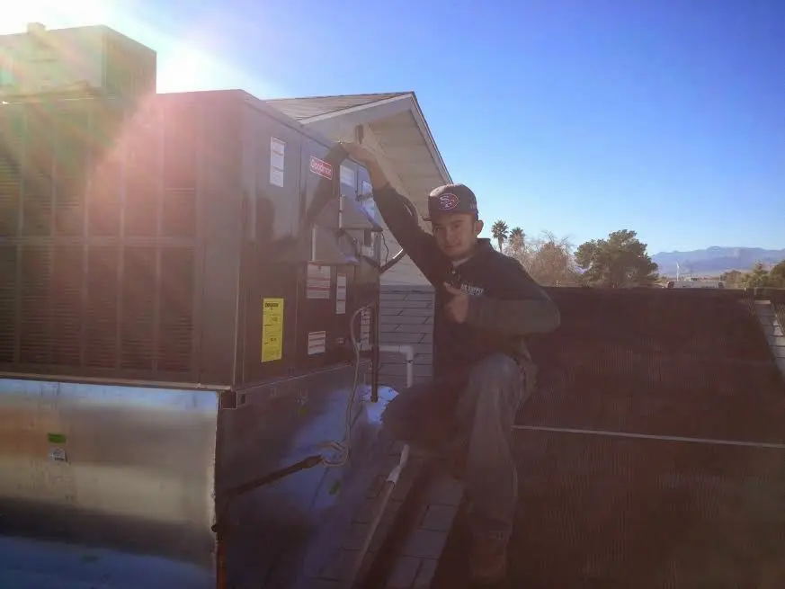 HVAC technician performing Heat Pump Repair on a rooftop unit in Grand Junction